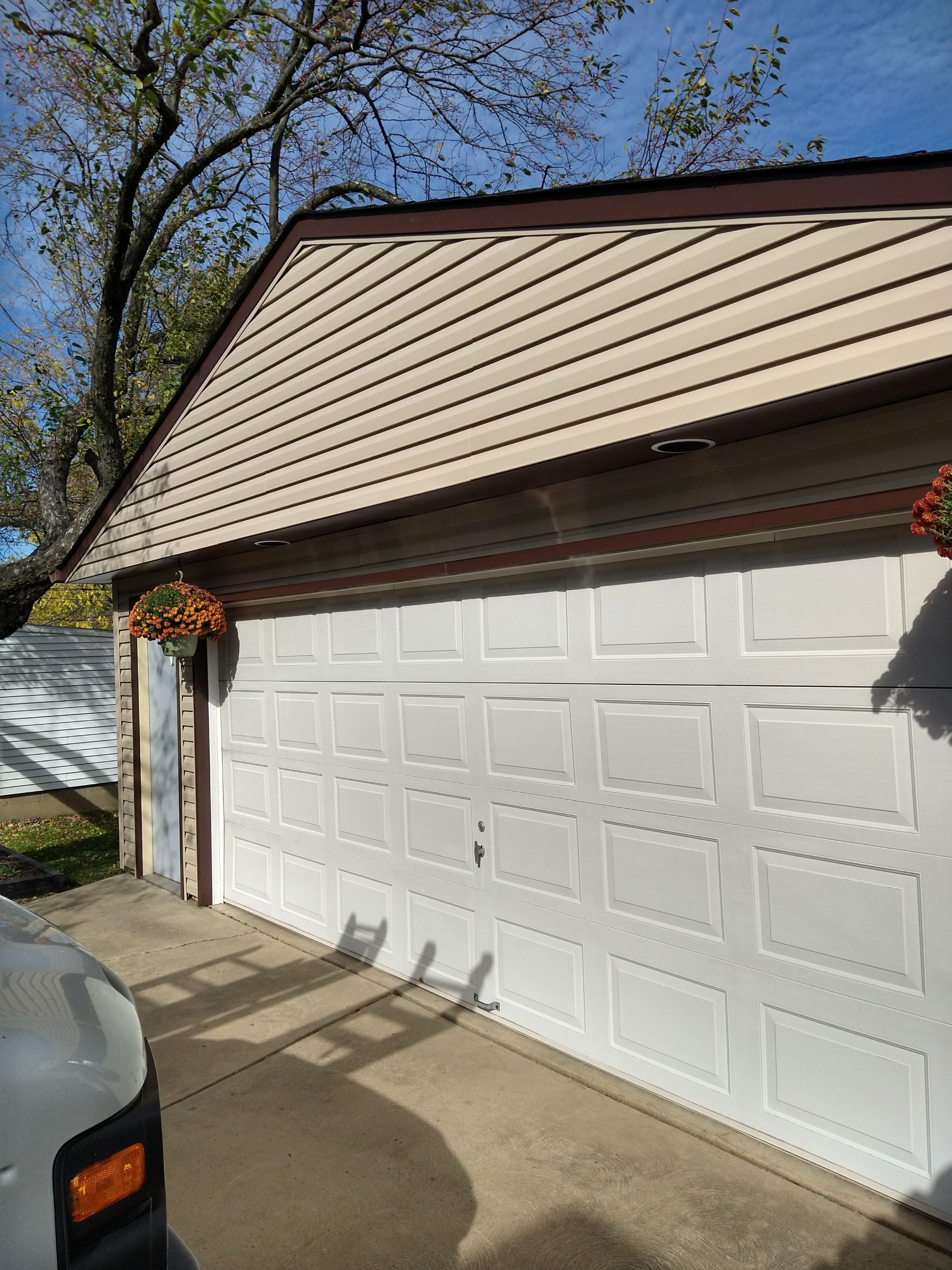 Siding Installation using Norandex woodsman dl-5 white woodgrain vinyl by Absolute Roofing and Construction