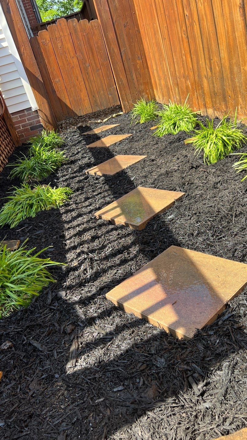 Liriope grasses, mulch and stone pavers by GrassBusters, Inc.