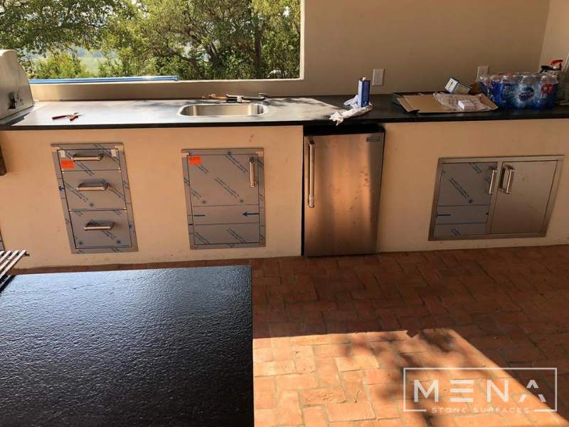 Kitchen, outdoor kitchen and pool brick floor installation by Mena stone surfaces