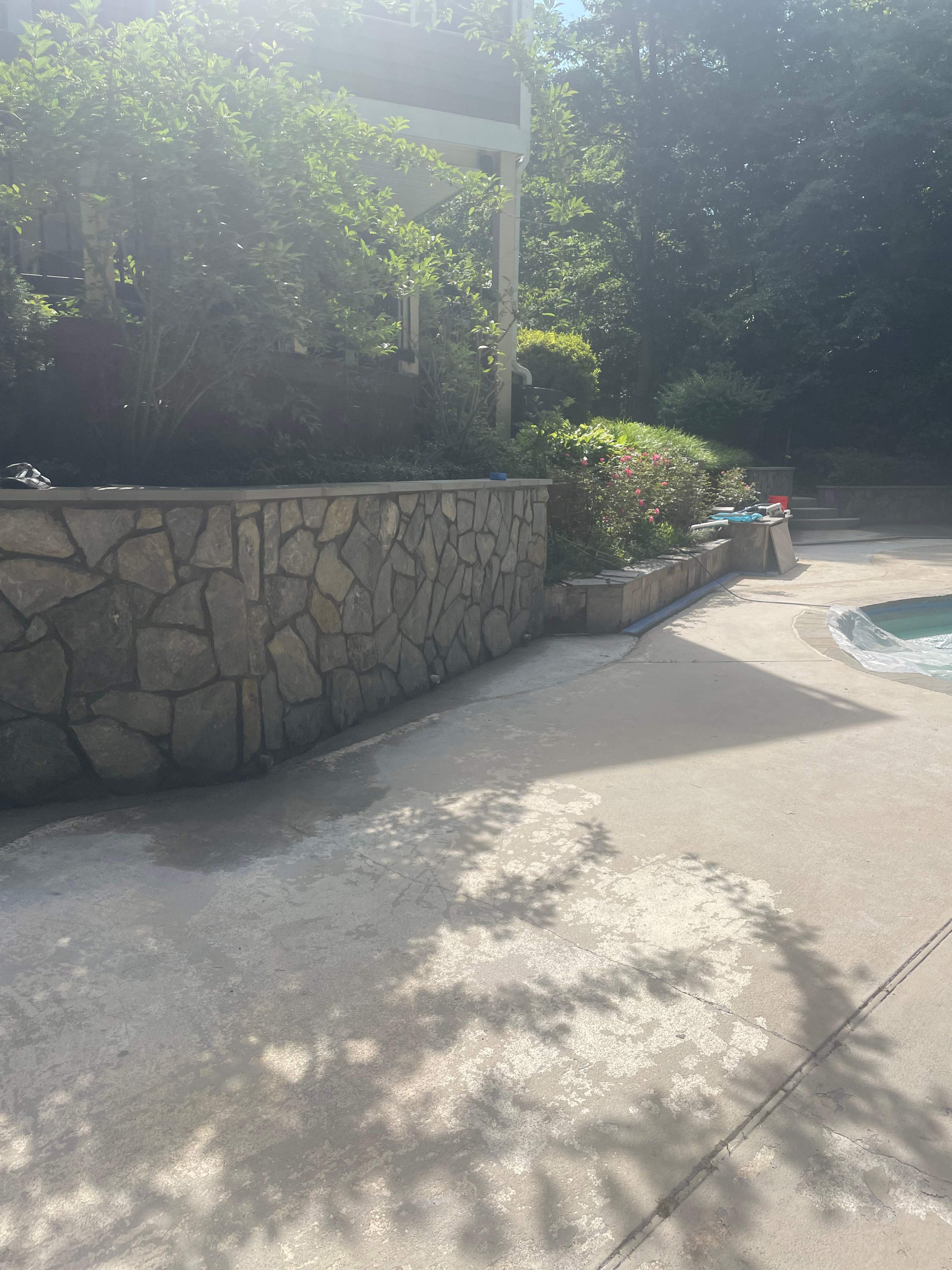 Pool Surround remodel with retaining walls, new waterfall and water slide by Fairfax Contractors, LLC