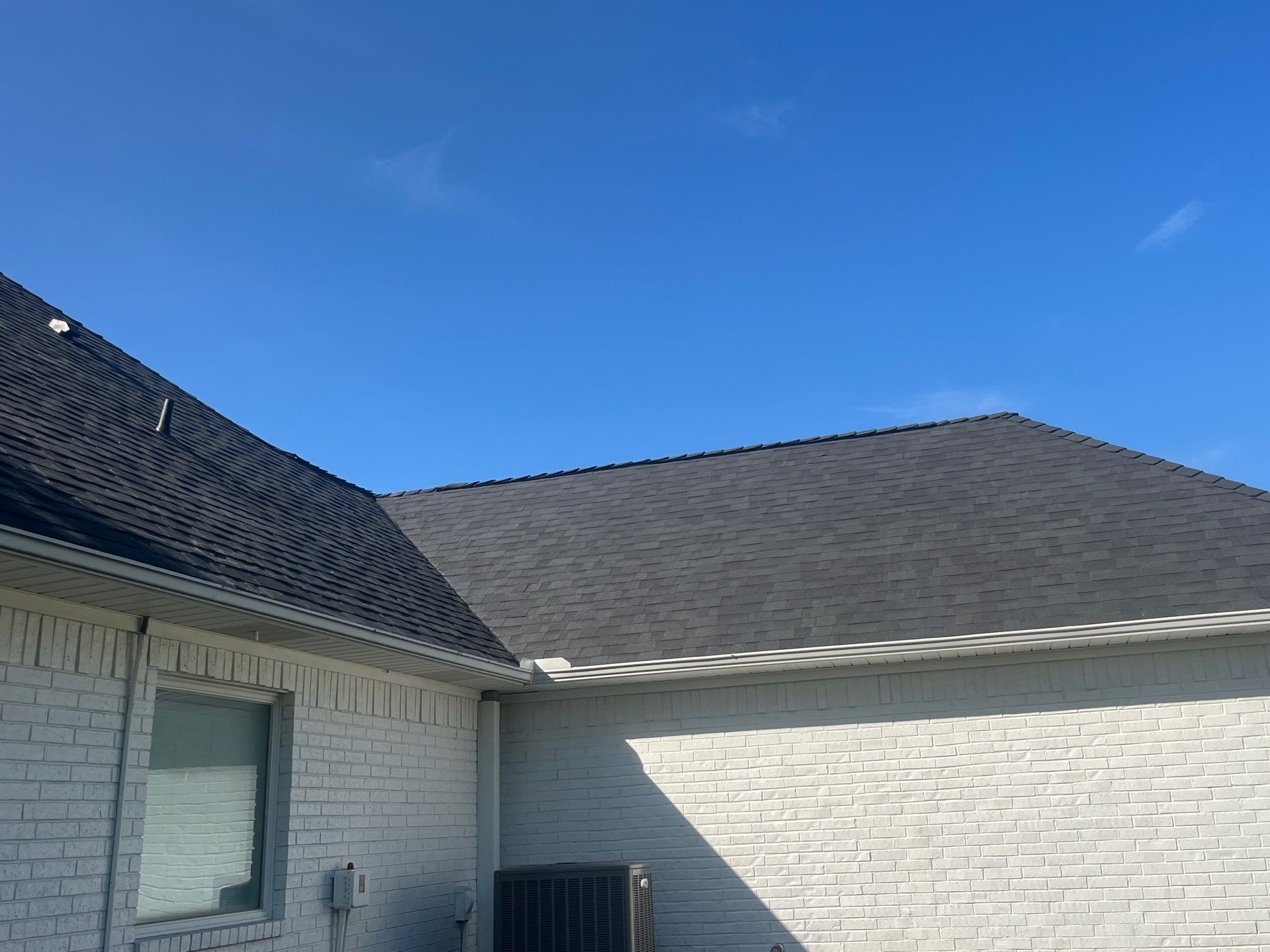 White brick with Malarkey Brilliant Black by Tejas Roofworks + Restoration