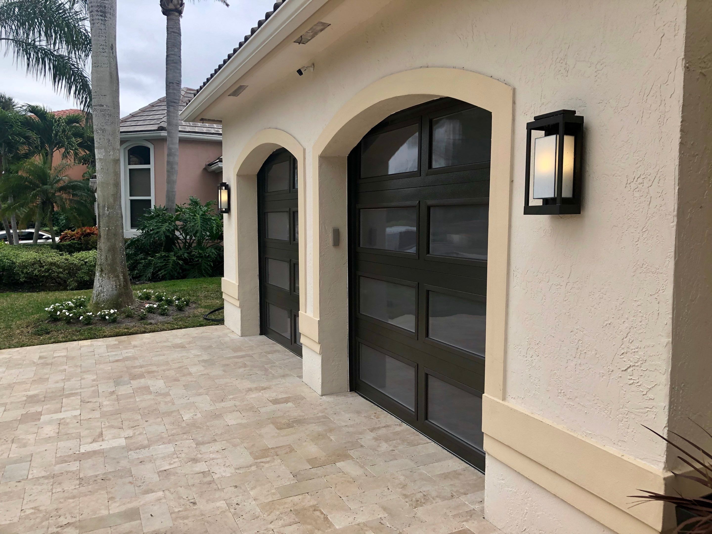 Modern Bronze Garage Door Installation With Frosted Glass in Boca Raton by The Door Doctor of South Florida, Inc.