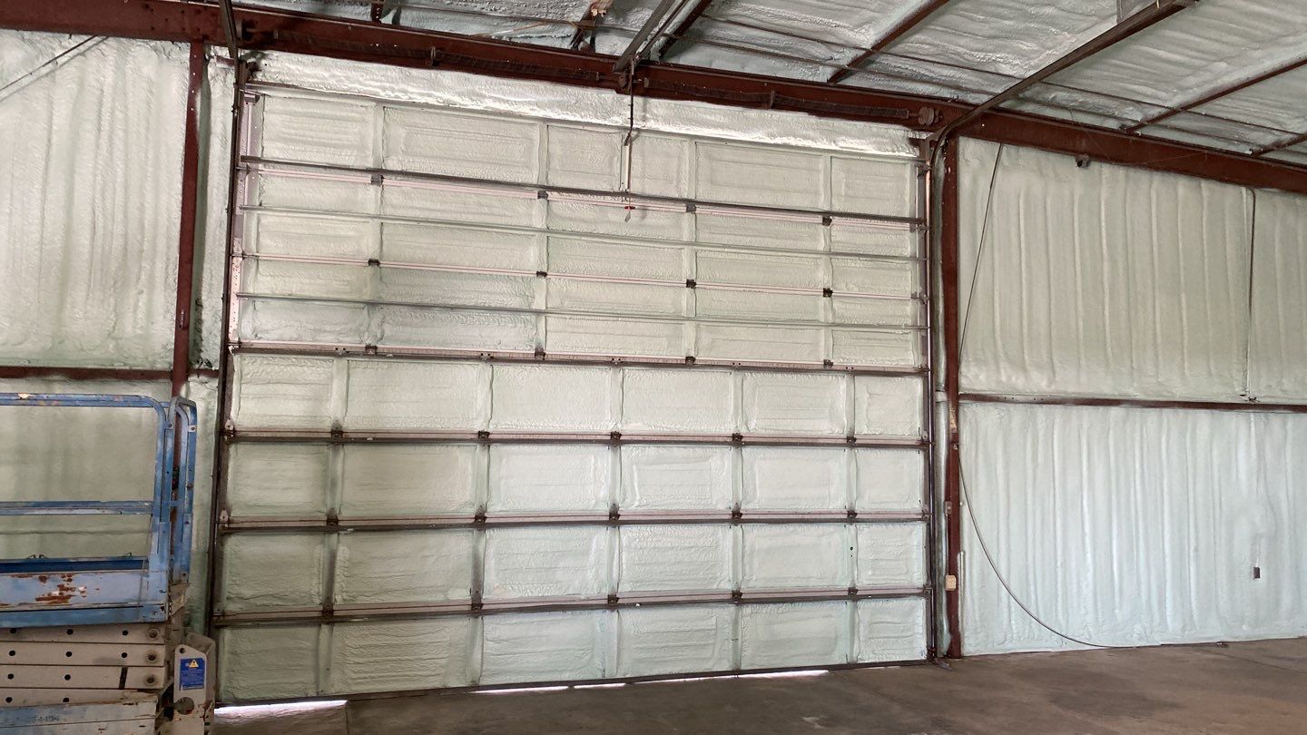 Spray foam insulation on inside of metal industrial building by Straight Edge Roofing Inc
