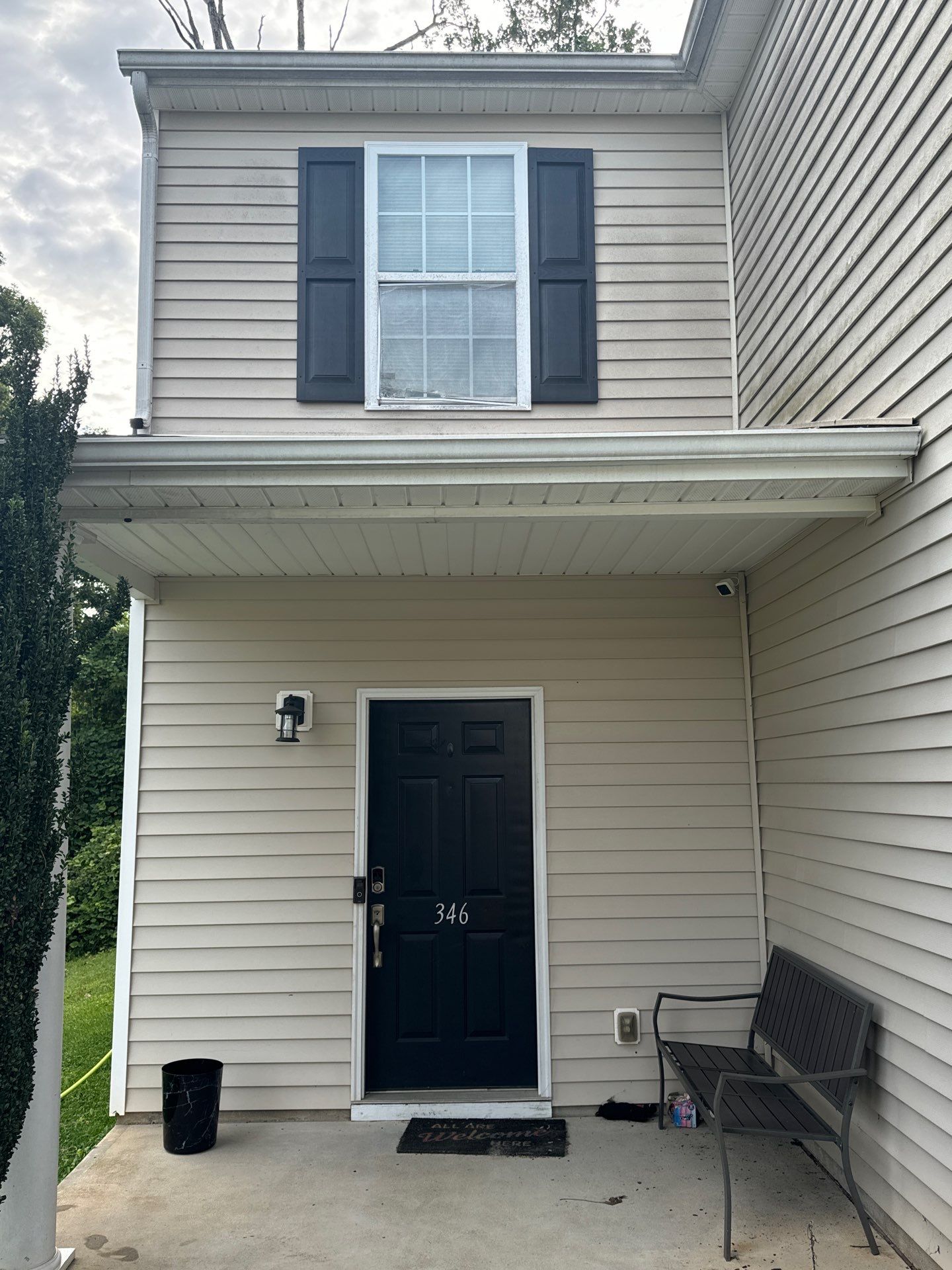 the service is cleaning the exterior siding and entryway surfaces to remove dirt and grime for a refreshed appearance