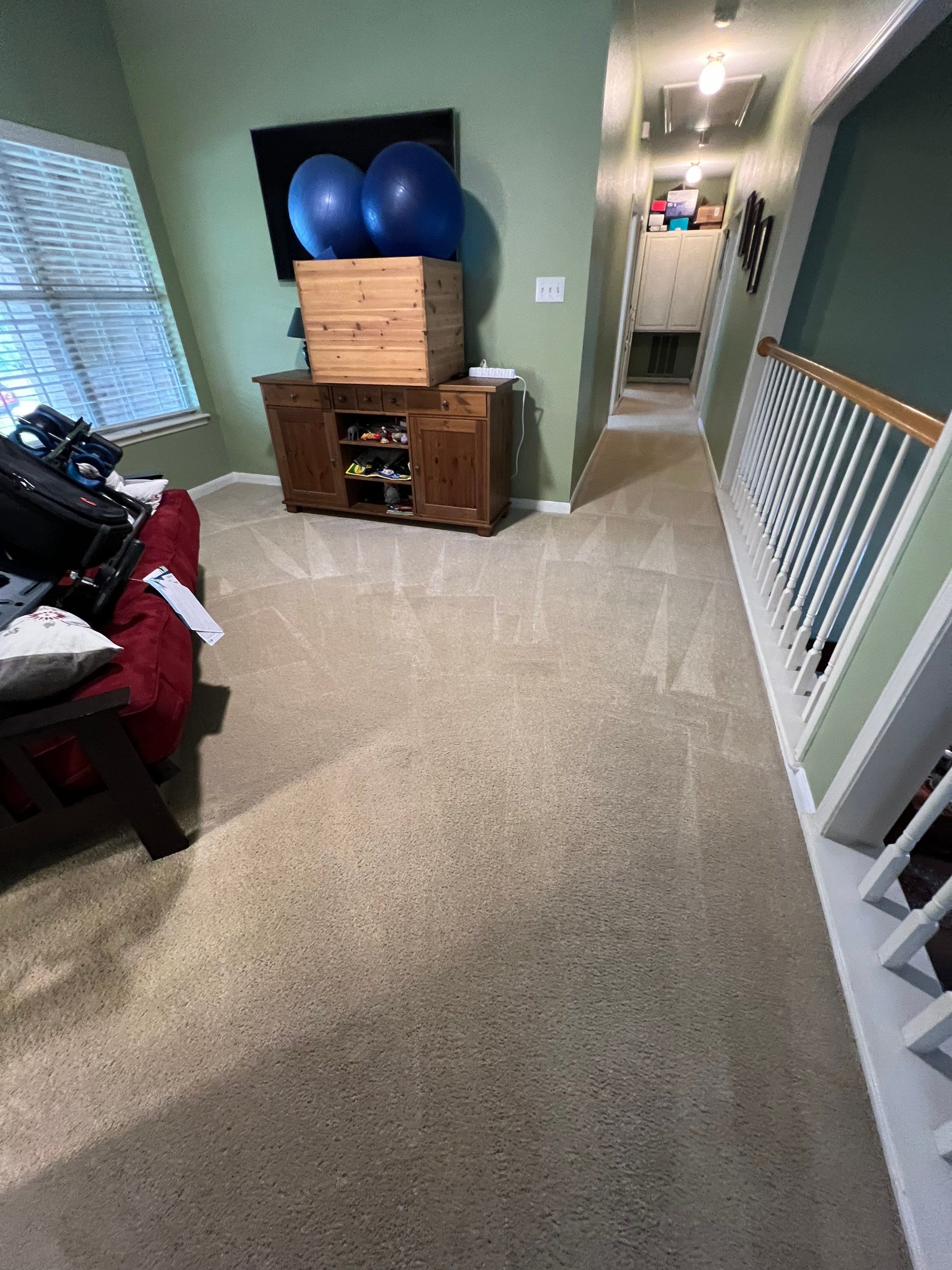 the service shown is carpet cleaning in a living area with light colored carpets and minimal furniture present