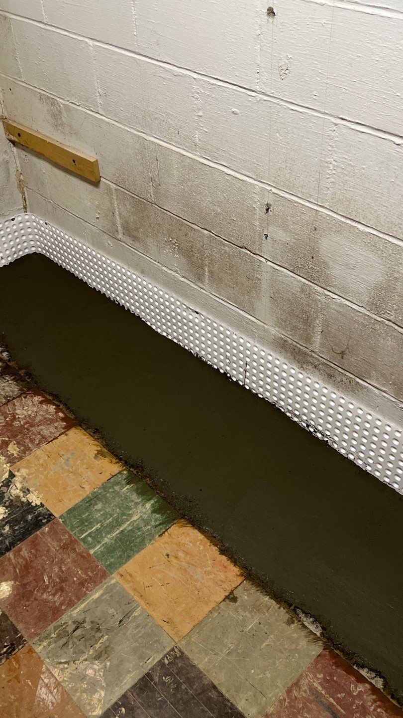 Interior drain tile system installation by ACE Waterproofing & Basement Solutions