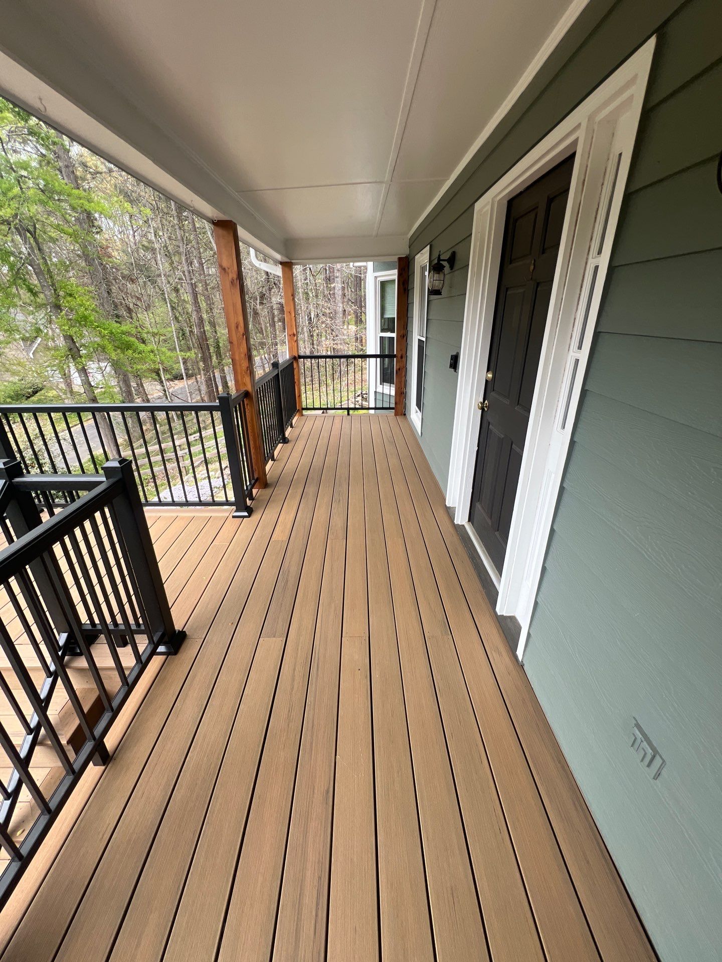 Composite Deck and Porch Renovation With Black Metal Railings by Swift Home Renovations 