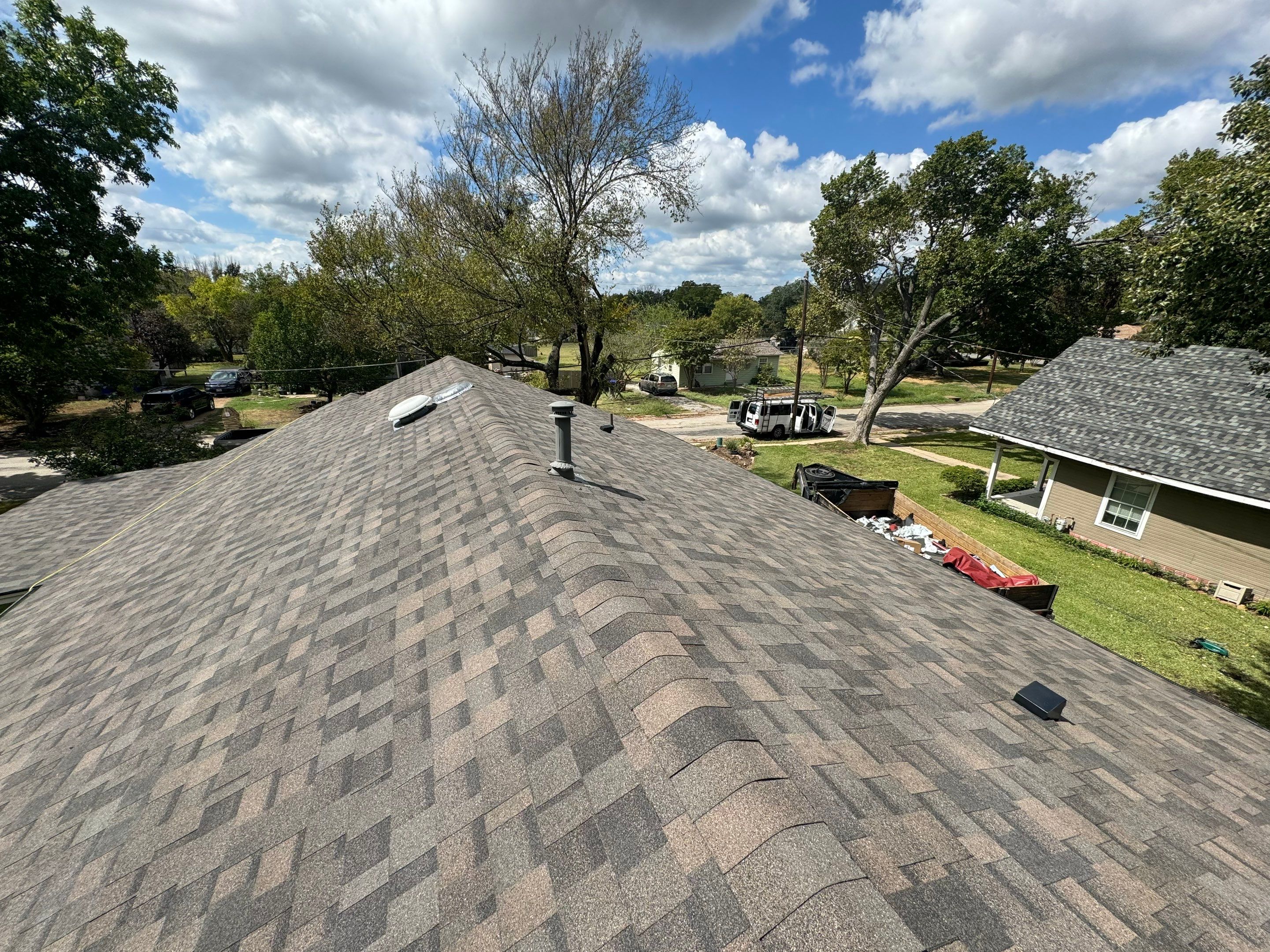 IKO Driftshake-Dark green siding house by Tejas Roofworks + Restoration