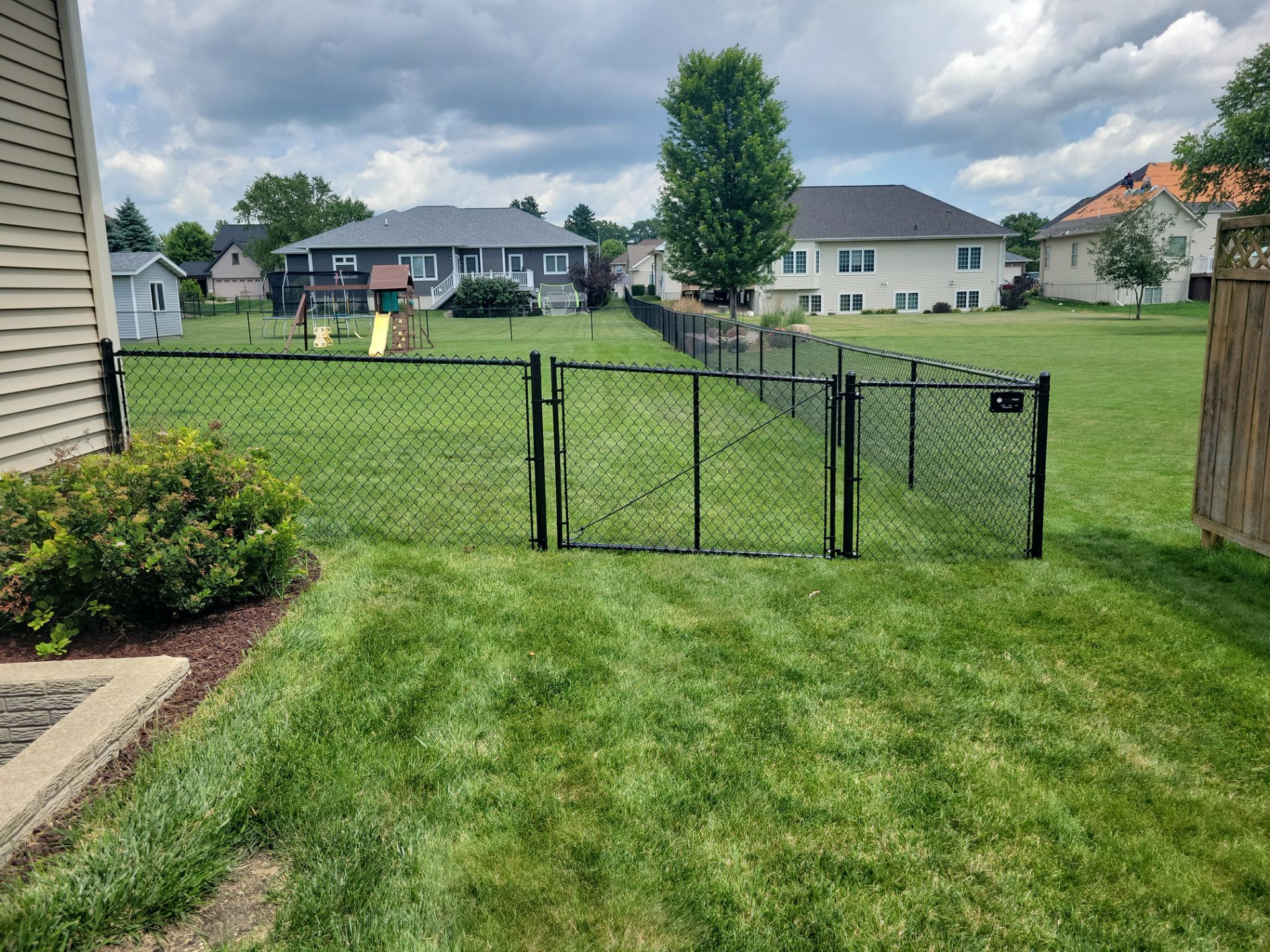 Black Vinyl Coated Chain Link Fence Installation in Cedar Falls by Perfect Picket Fence and Stain